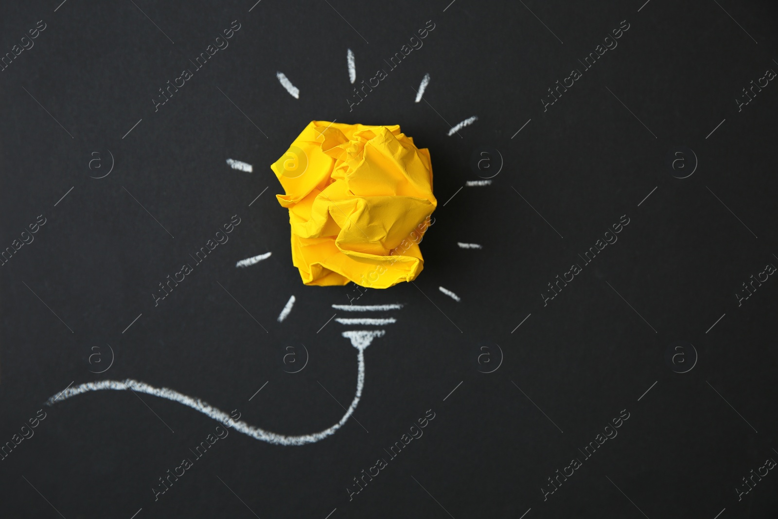 Photo of Composition with crumpled paper as lamp bulb and space for text on black background