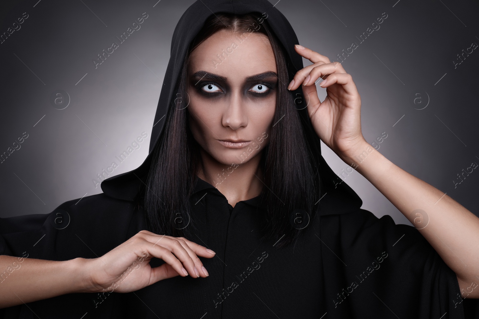 Photo of Mysterious witch with spooky eyes on dark background