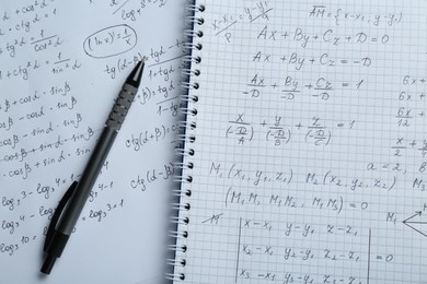Photo of Paper with different mathematical formulas and pen, top view