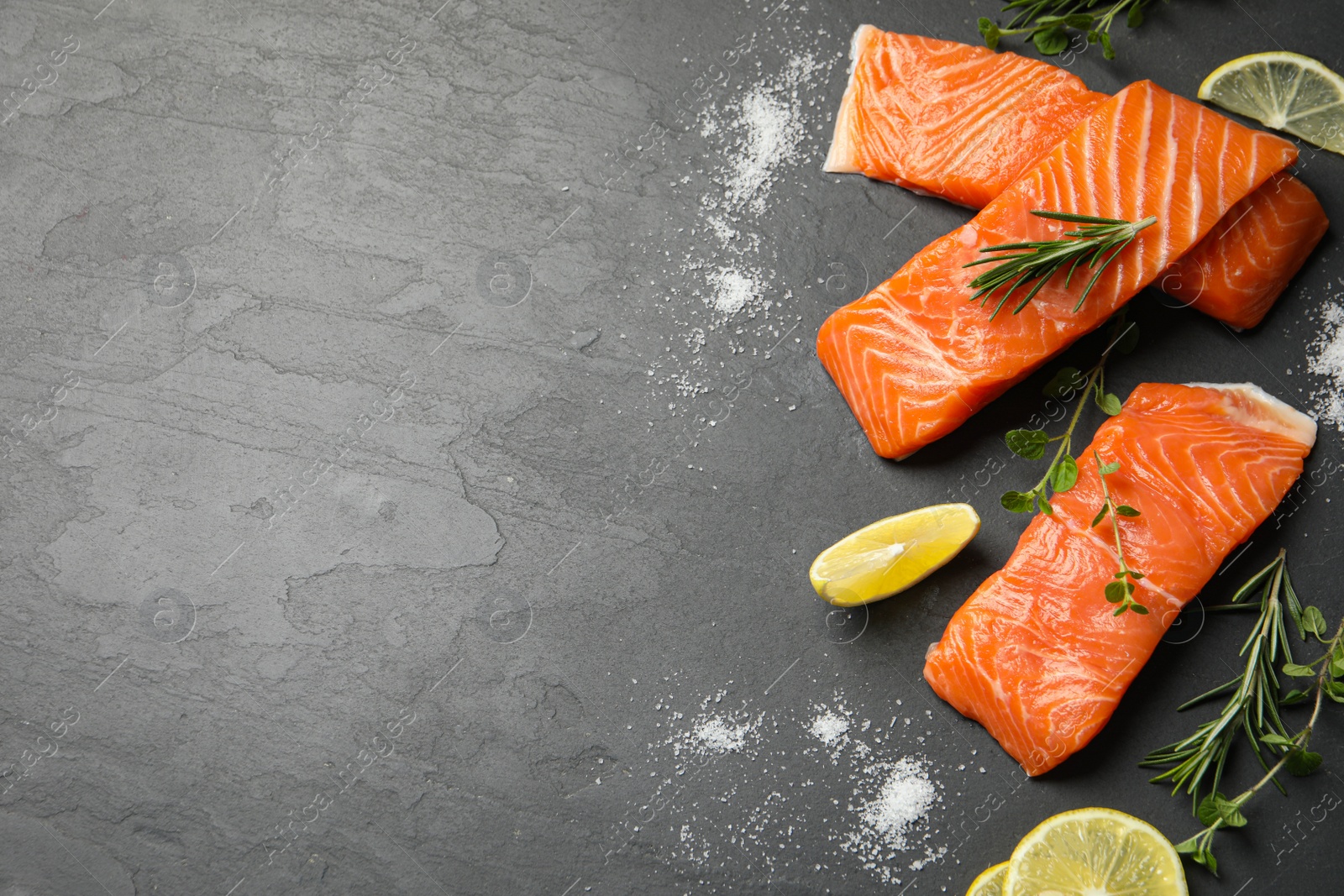 Photo of Fresh salmon and ingredients for marinade on black table, flat lay. Space for text