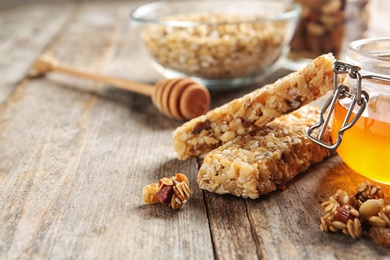 Homemade grain cereal bars and honey on wooden table. Healthy snack