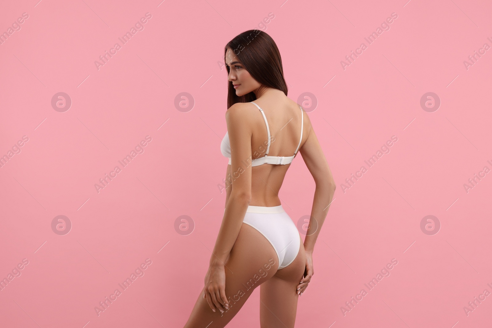 Photo of Young woman in stylish white bikini on pink background