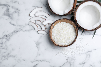 Photo of Flat lay composition with fresh coconut flakes on white marble table. Space for text