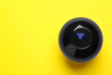 Photo of Magic eight ball with prediction The Stars Say No on yellow background, top view. Space for text