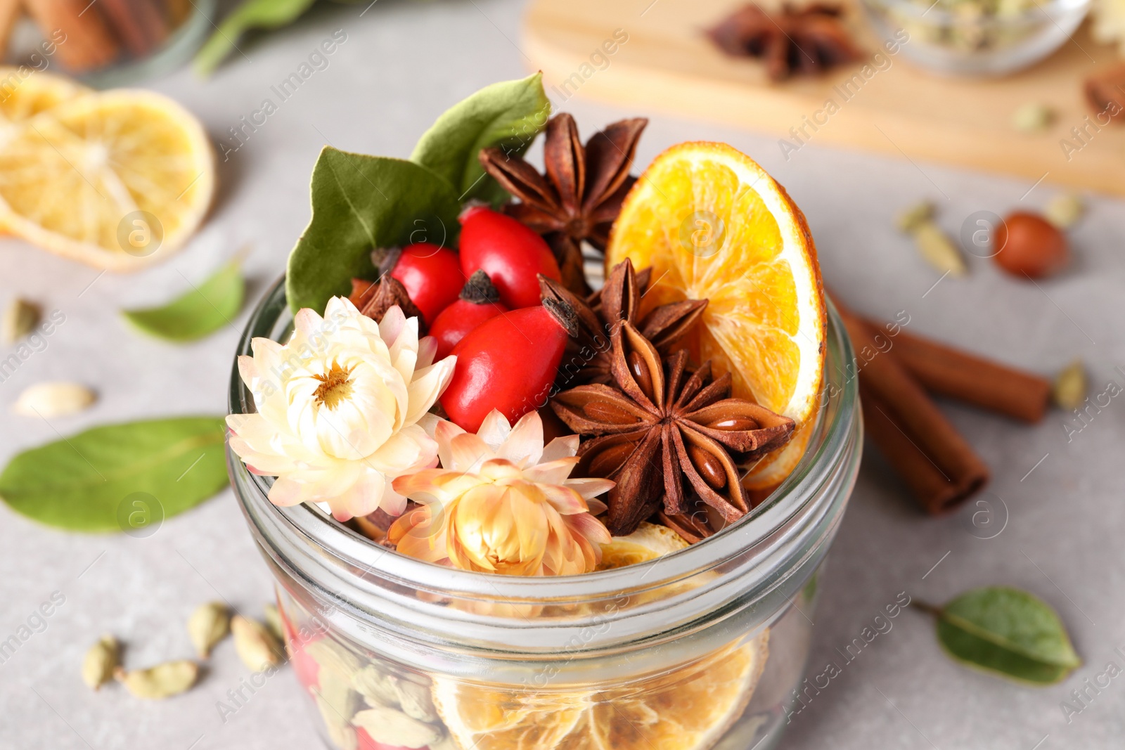 Photo of Aromatic potpourri in glass jar on table, closeup