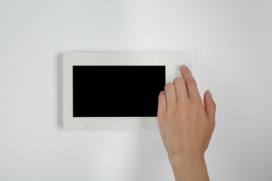 Photo of Woman using modern video intercom indoors, closeup