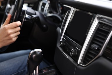 Woman using navigation system while driving her car, closeup