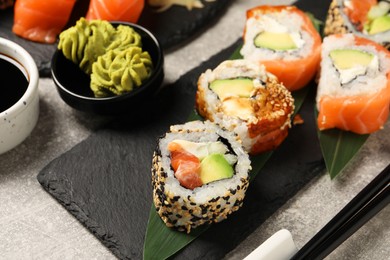 Photo of Delicious sushi rolls and wasabi on light grey table, closeup