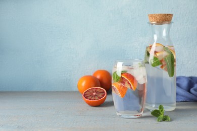 Delicious refreshing drink with sicilian orange and mint on grey wooden table. Space for text