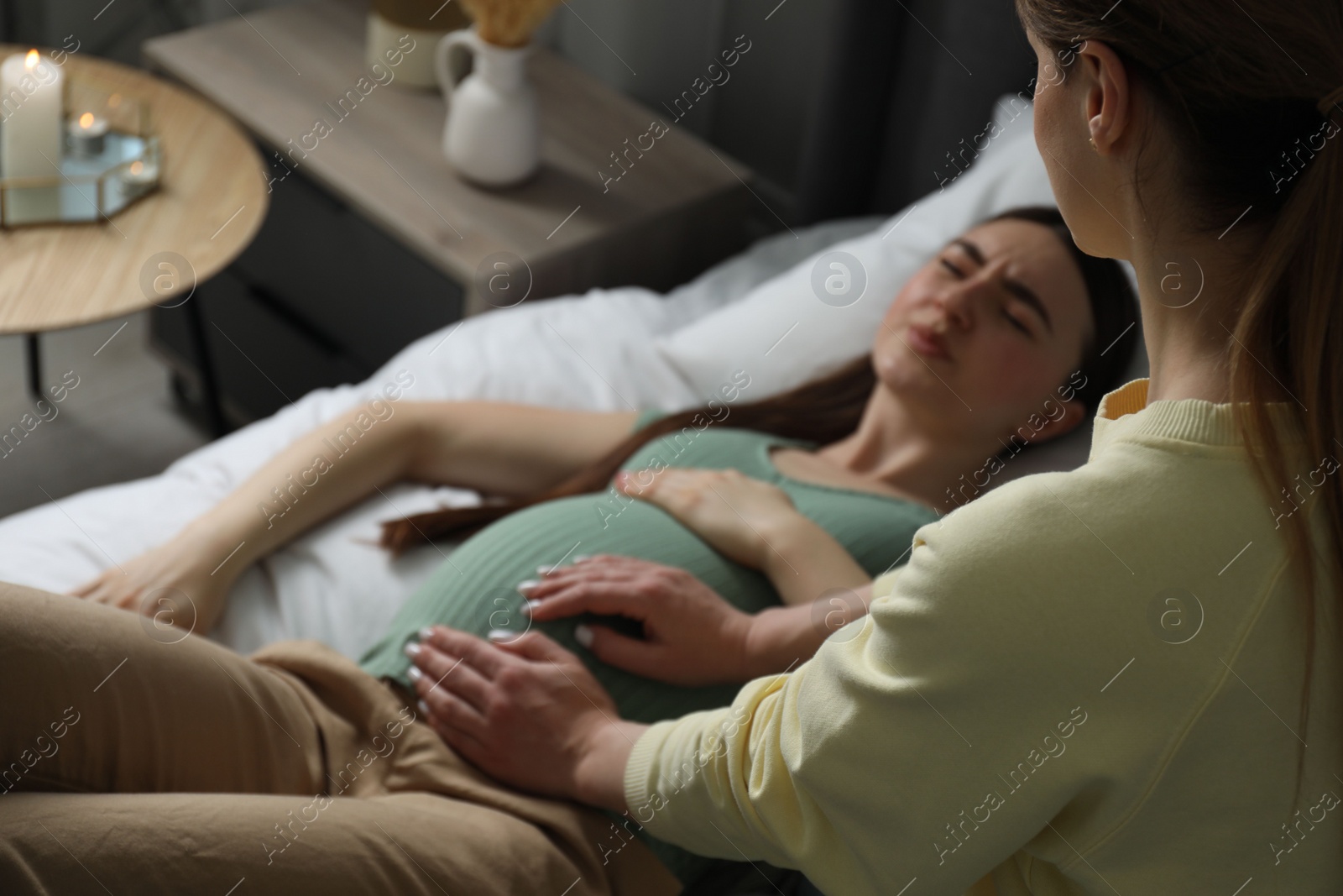 Photo of Doula working with pregnant woman indoors. Preparation for child birth