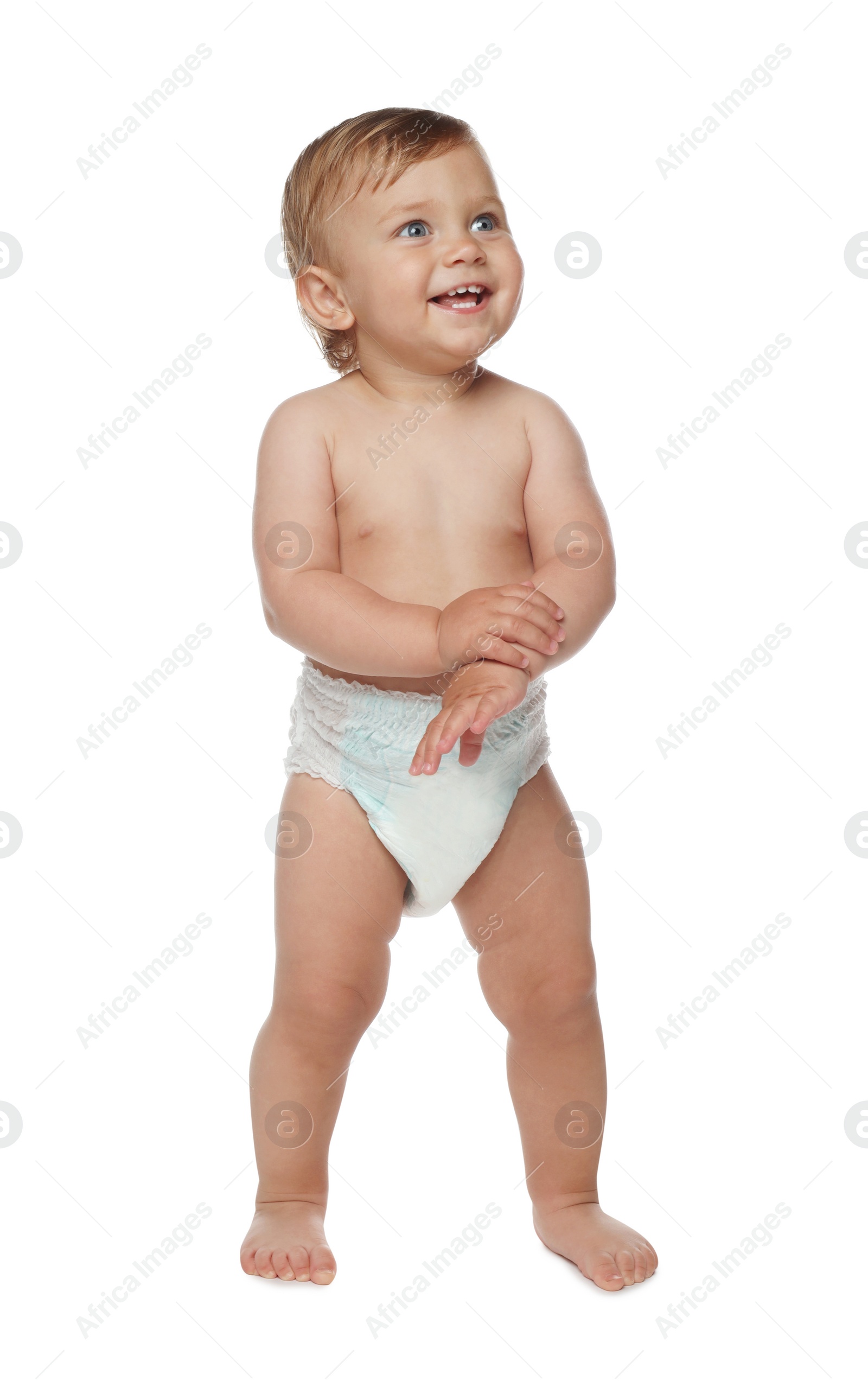 Photo of Cute baby in diaper learning to walk on white background