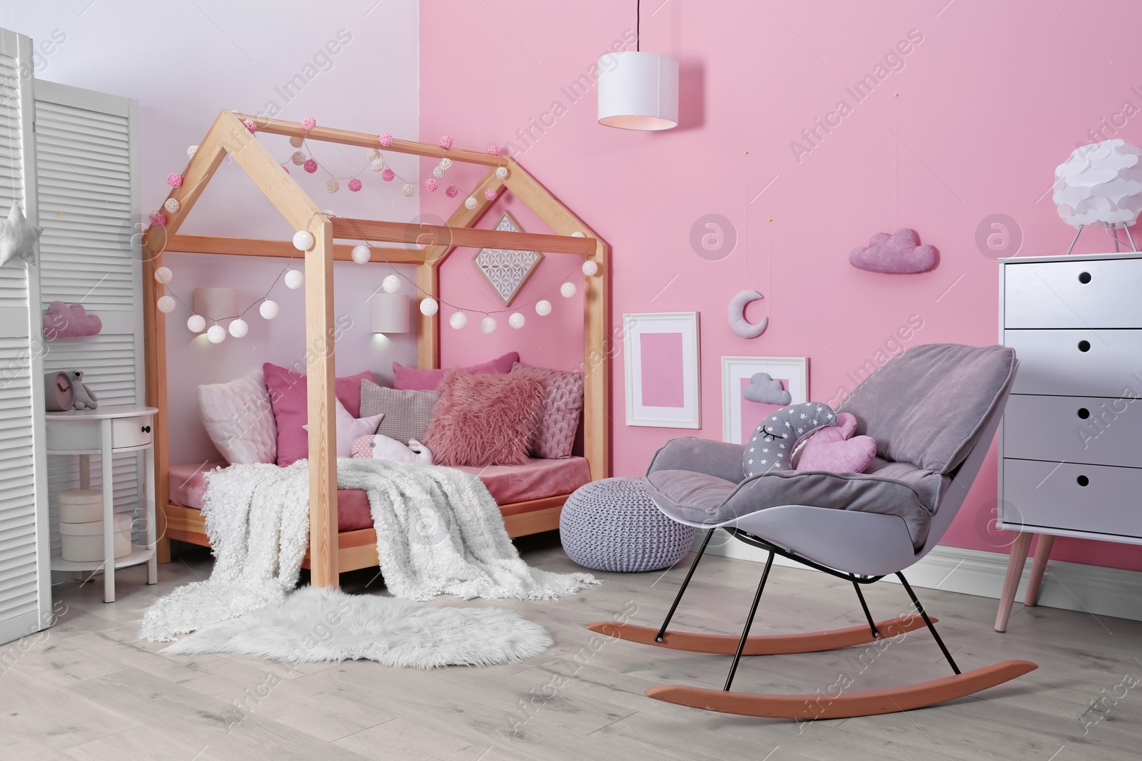 Photo of Child's room interior with comfortable bed and garland