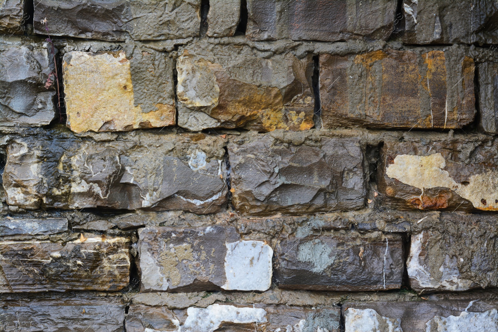 Photo of Wall with different stone fragments as background, closeup