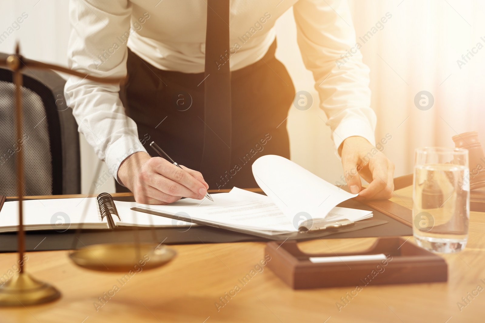 Image of Lawyer working with documents at wooden table in office, closeup