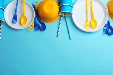 Photo of New plastic dishware and space for text on color background. Table setting
