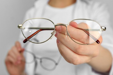 Photo of Woman with glasses on light background, closeup