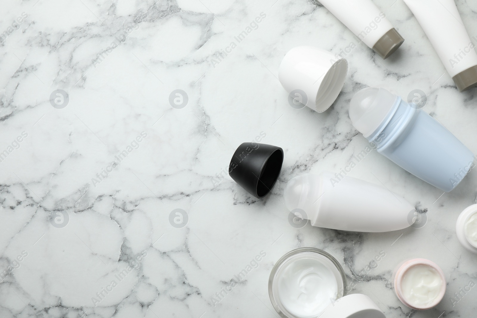 Photo of Flat lay composition with natural deodorants on white marble table. Space for text