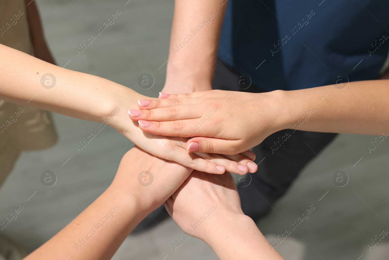 Photo of Group of people holding hands together indoors, closeup. Unity concept