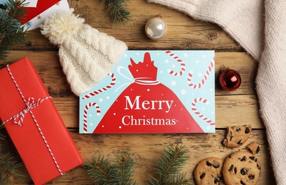 Photo of Flat lay composition with Christmas card and festive decor on wooden background