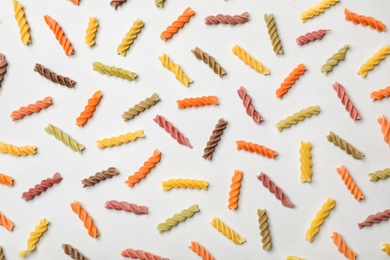 Flat lay composition with raw pasta on white background