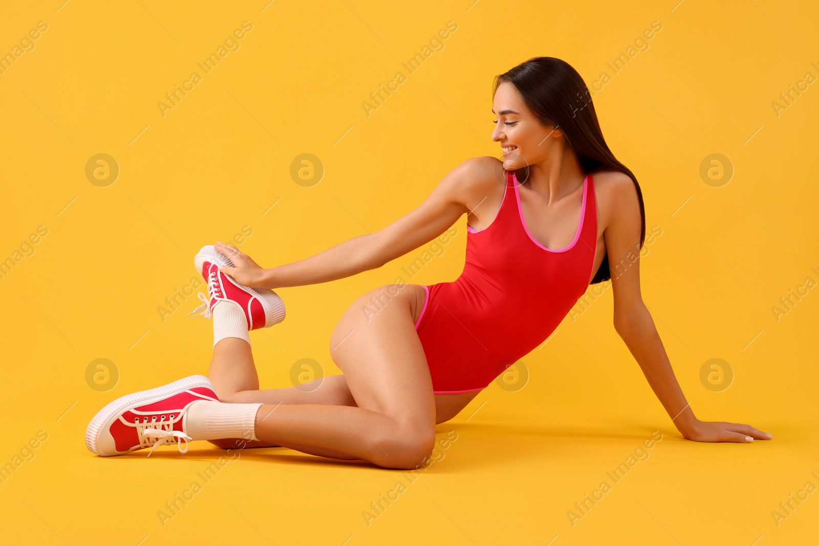 Photo of Young woman in stylish swimsuit on yellow background