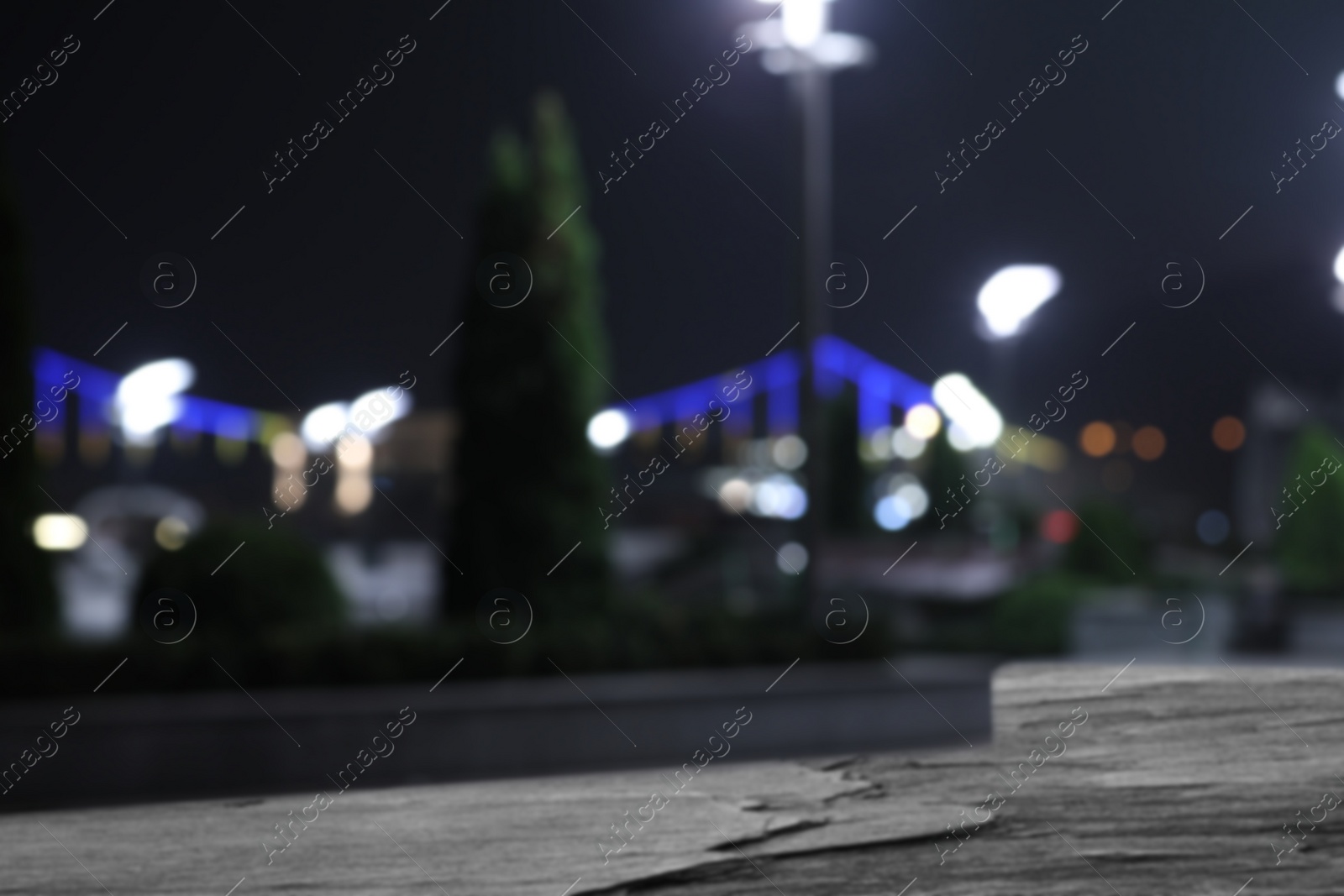 Image of Empty stone surface and blurred view of night city