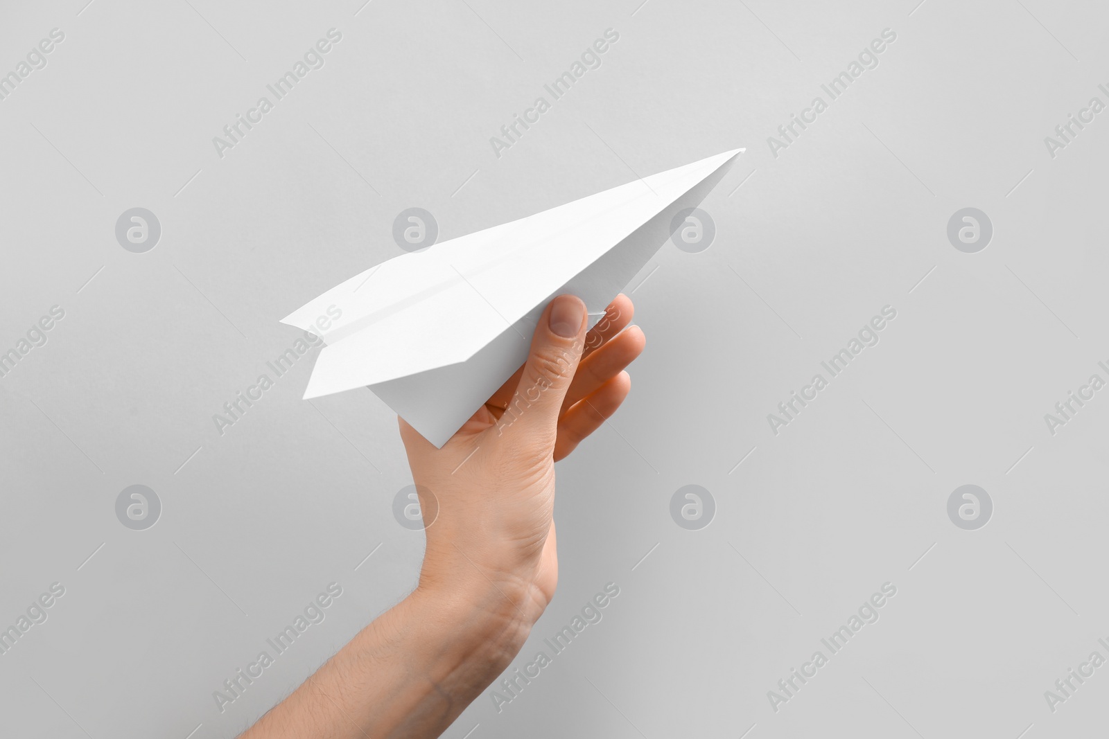 Photo of Woman holding paper plane on white background, closeup