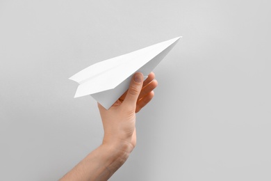 Photo of Woman holding paper plane on white background, closeup