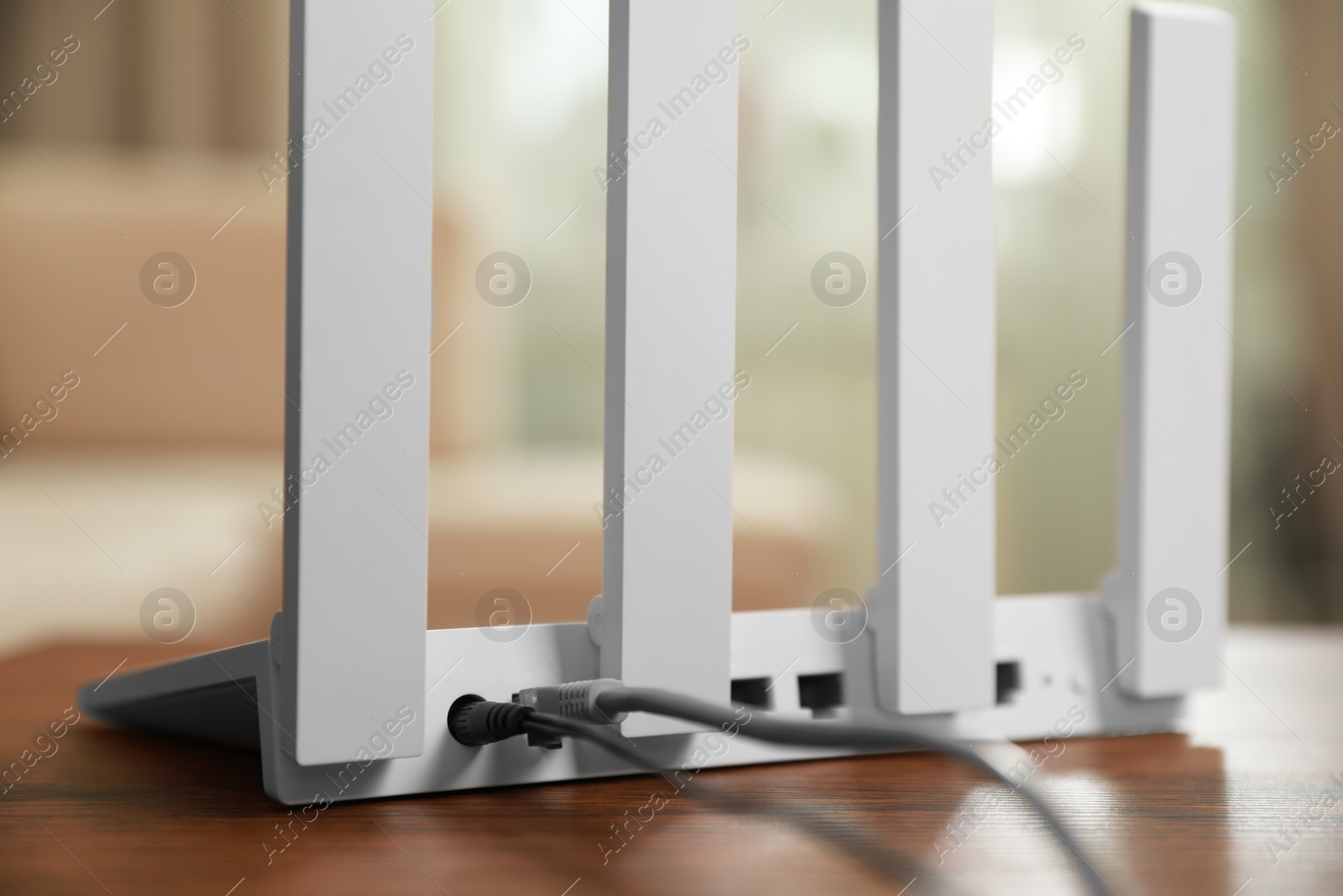 Photo of New modern Wi-Fi router on wooden table indoors, closeup