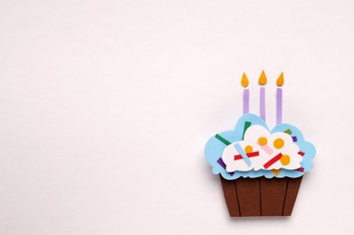 Photo of Birthday party. Paper cupcake with candles on white background, top view and space for text