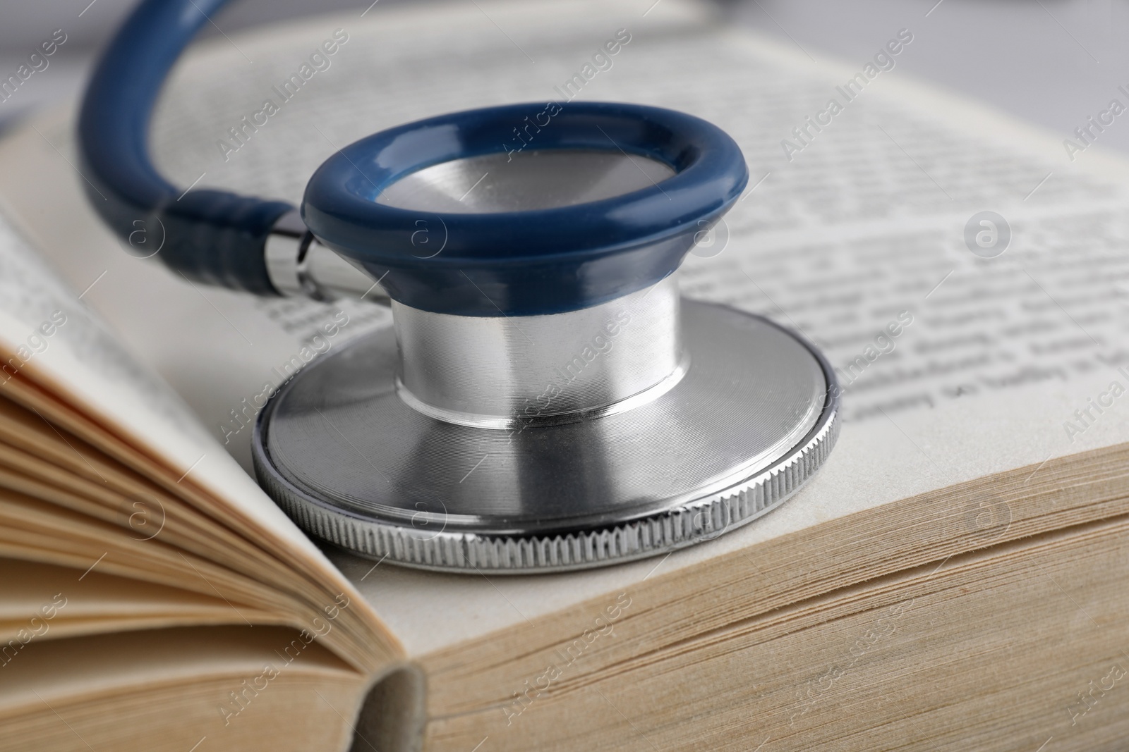 Photo of Open student textbook with and stethoscope, closeup. Medical education