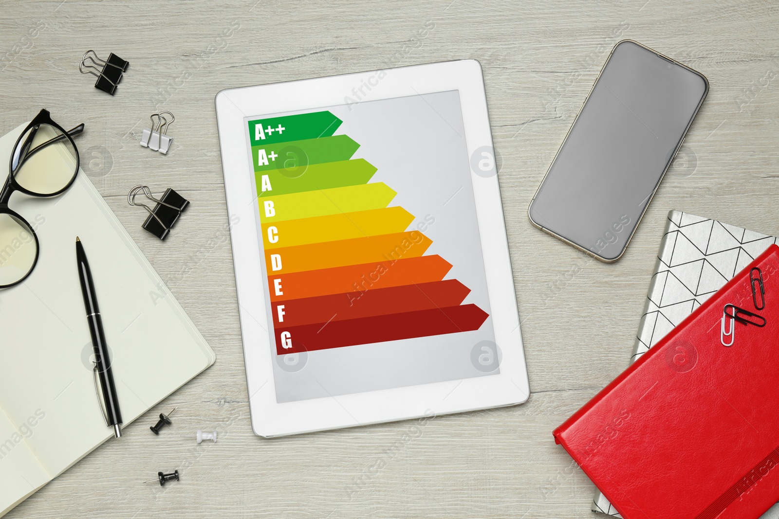 Image of Energy efficiency rating on tablet display. Flat lay composition on table