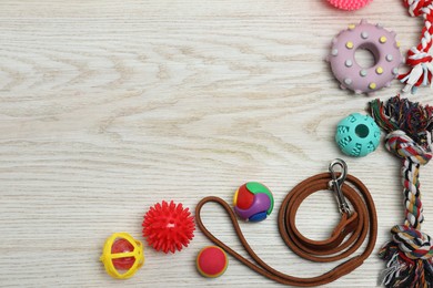 Photo of Flat lay composition with dog leash and toys on white wooden background, space for text