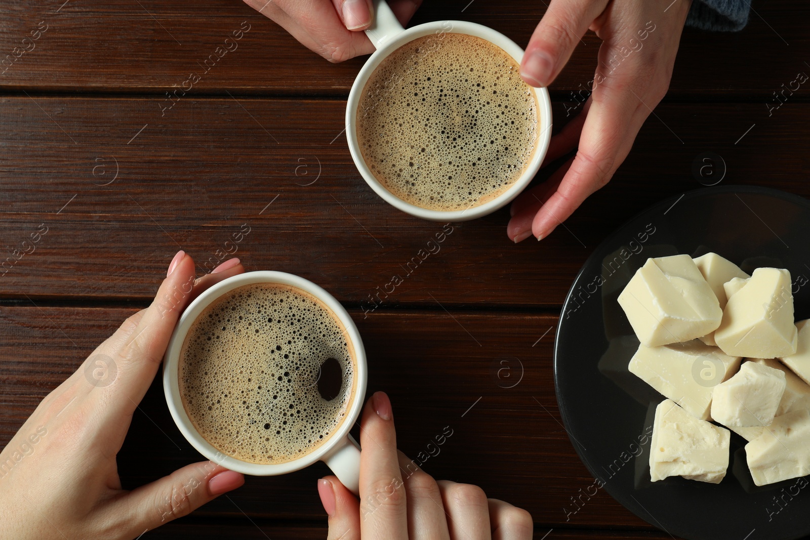 Photo of Women having coffee break at wooden table, top view