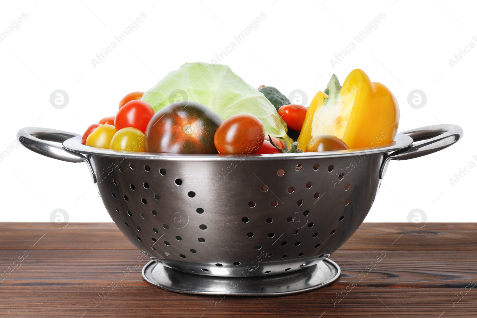 Photo of Metal colander with different vegetables on wooden table against white background