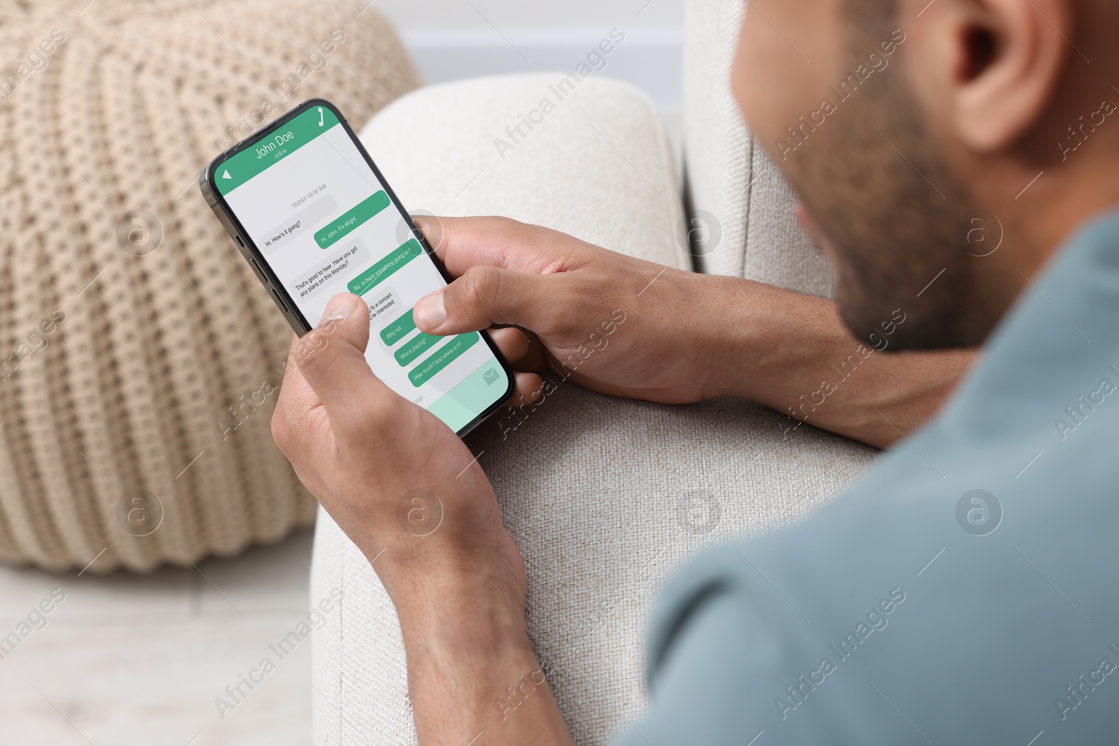 Image of Man texting via mobile phone indoors, closeup. Device screen with messages