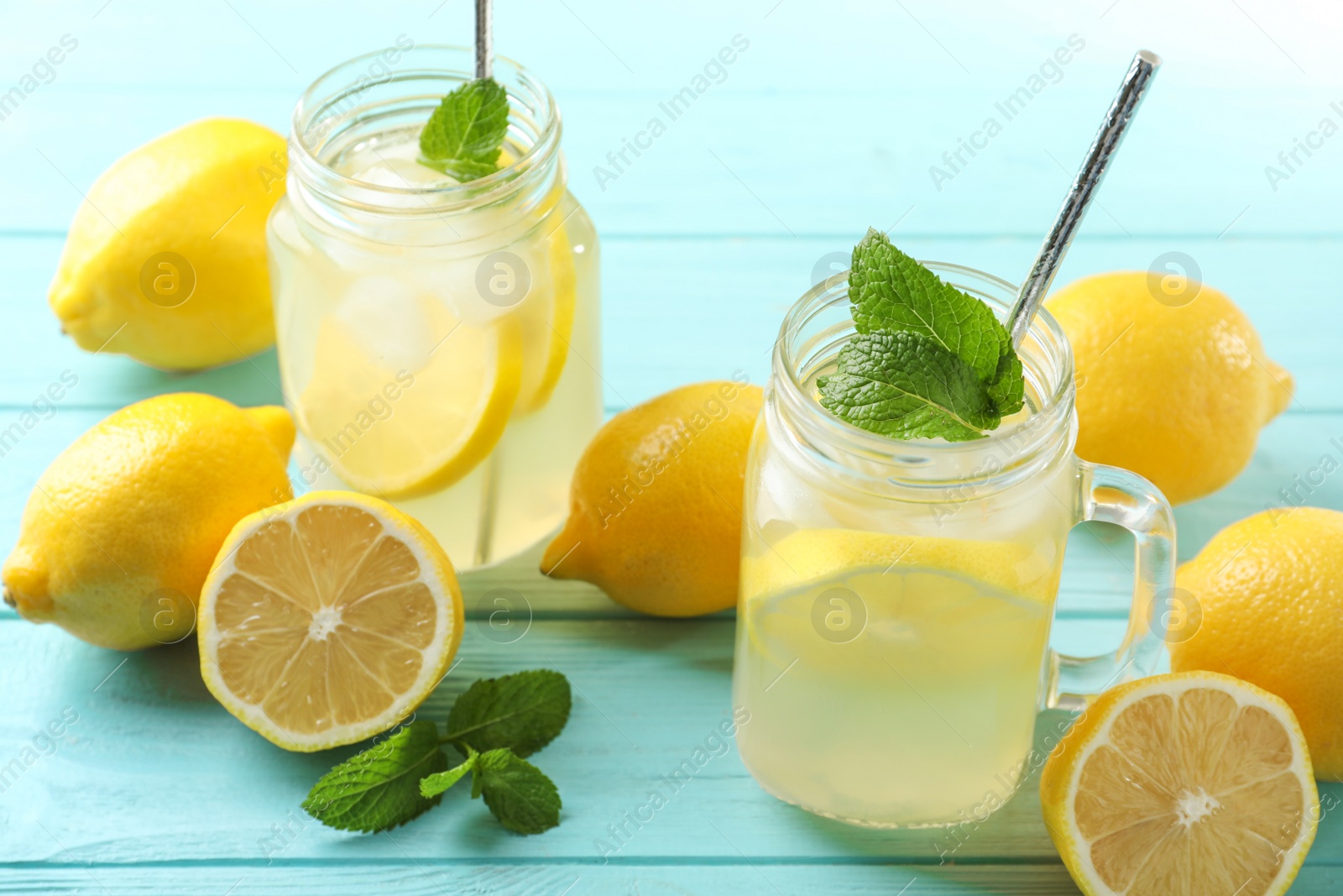 Photo of Natural lemonade with mint on light blue wooden table. Summer refreshing drink