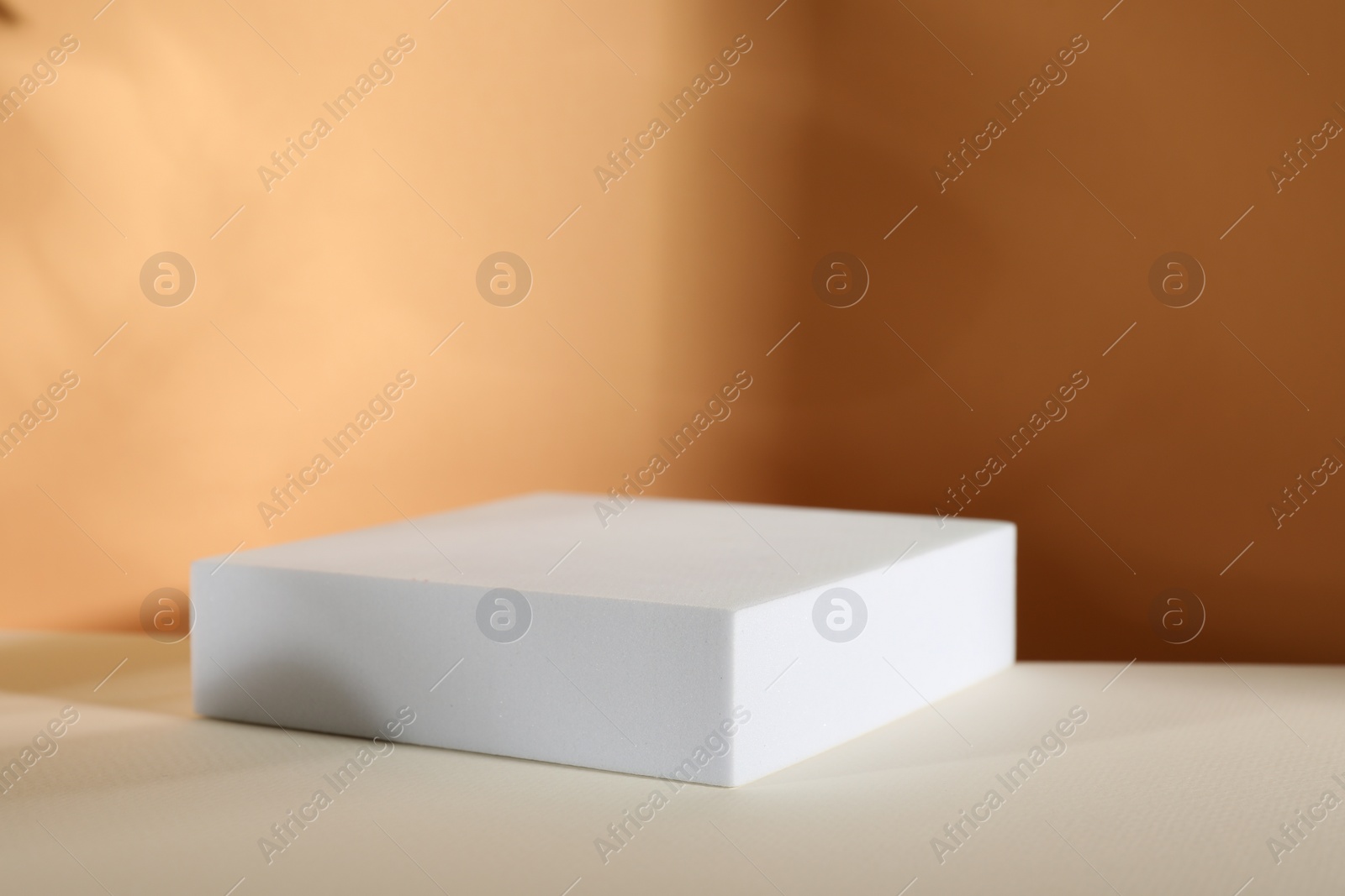 Photo of Presentation of product. Podium and shadows on orange background. Space for text