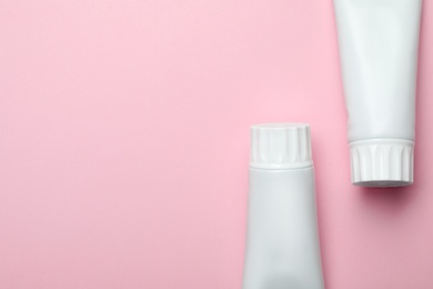 Photo of Blank tubes of toothpaste on color background, top view with space for text