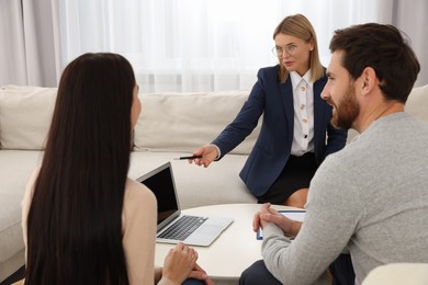 Photo of Real estate agent consulting couple in new apartment