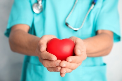 Doctor holding red heart, closeup. Cardiology concept