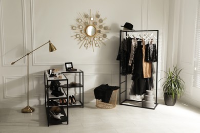 Photo of Stylish dressing room interior with trendy clothes, shoes and accessories