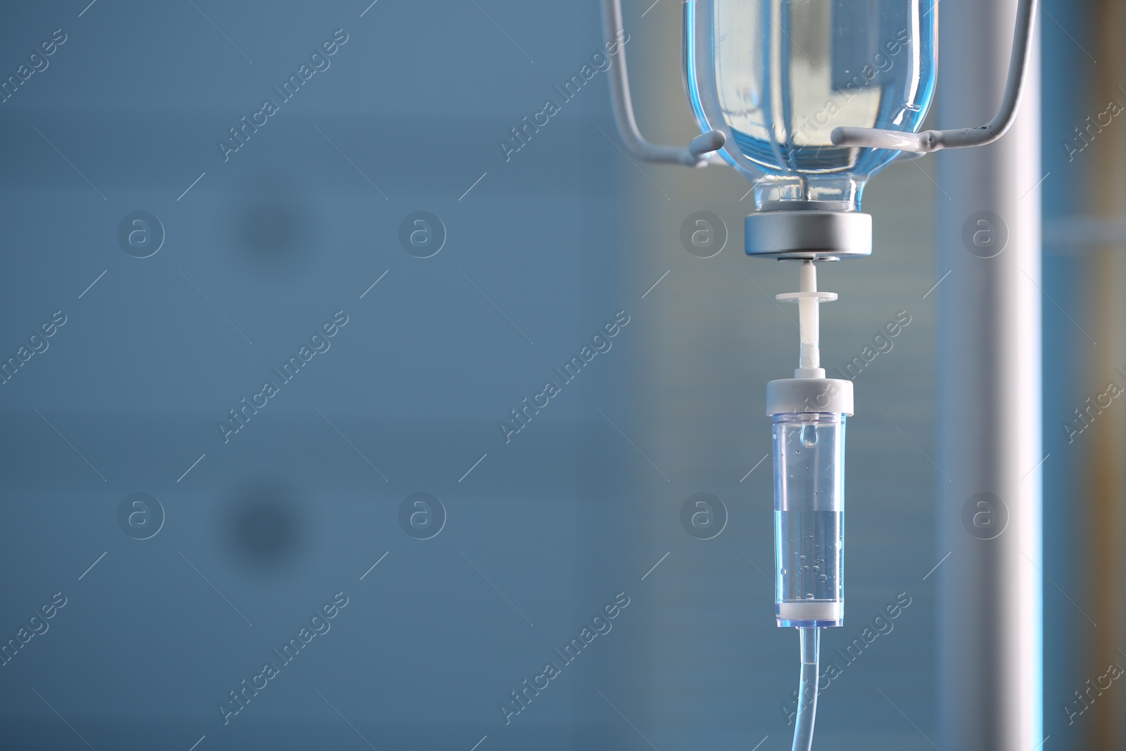 Photo of IV drip against blurred background, space for text