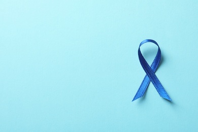 Photo of Blue ribbon on color background, top view. Cancer awareness