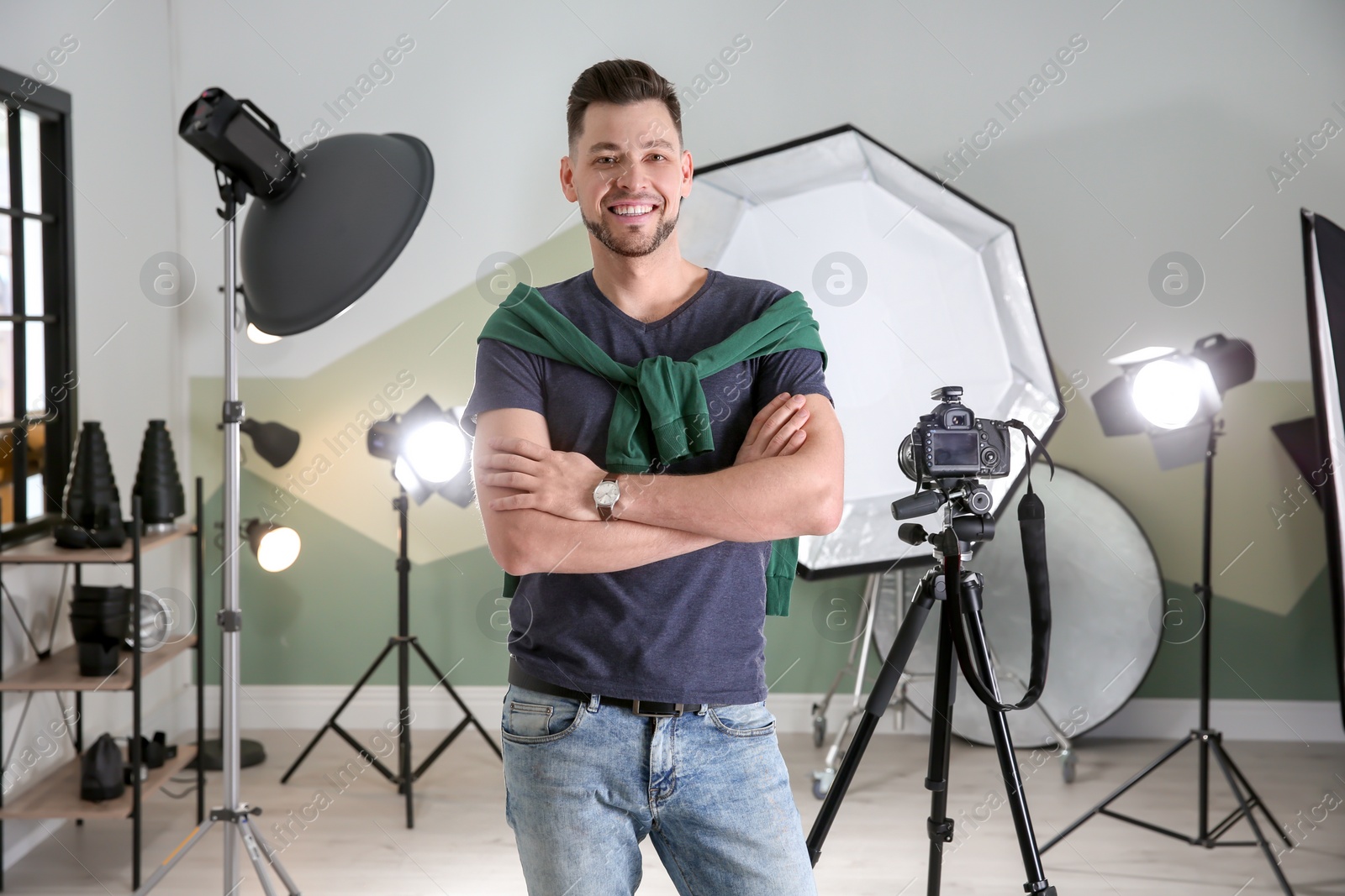 Photo of Professional photographer with camera and lighting equipment in studio