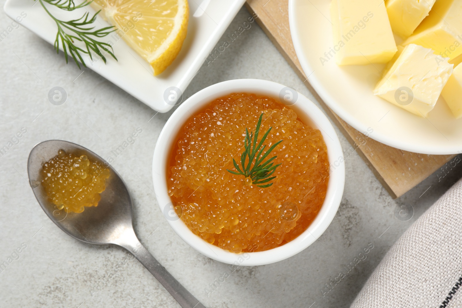 Photo of Fresh pike caviar, dill, butter and lemon on light grey table, top view