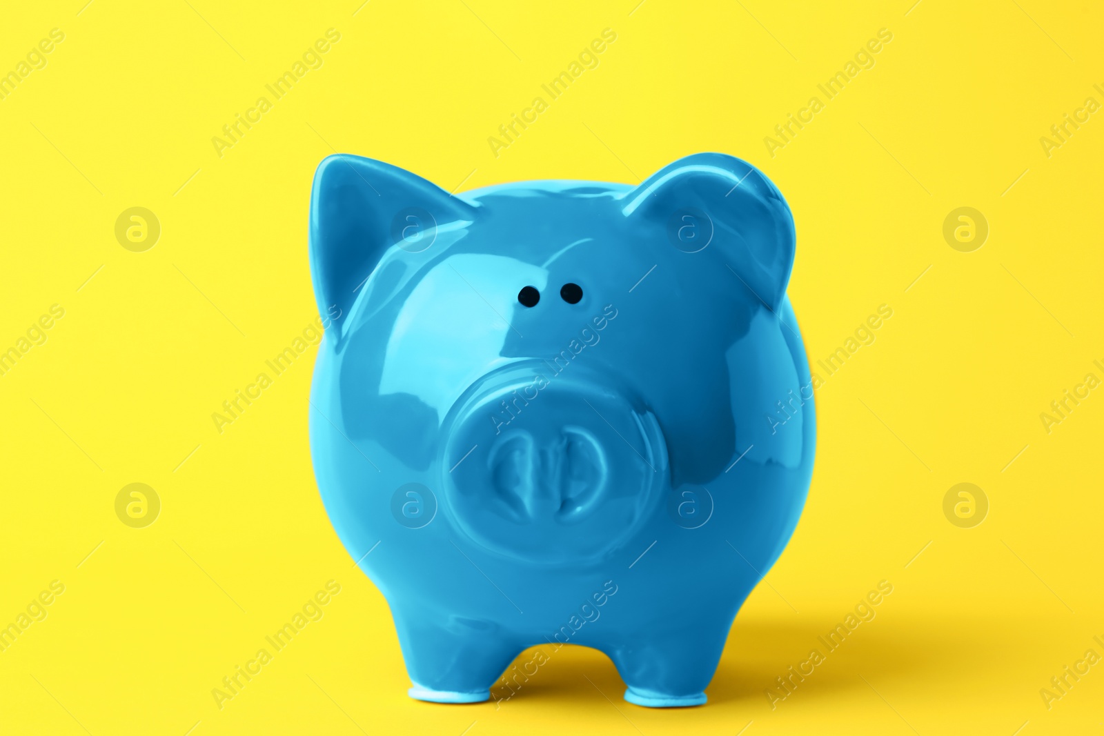 Photo of Ceramic piggy bank on yellow background. Financial savings