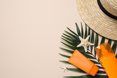 Photo of Flat lay composition with sun protection products and hat on beige background. Space for text