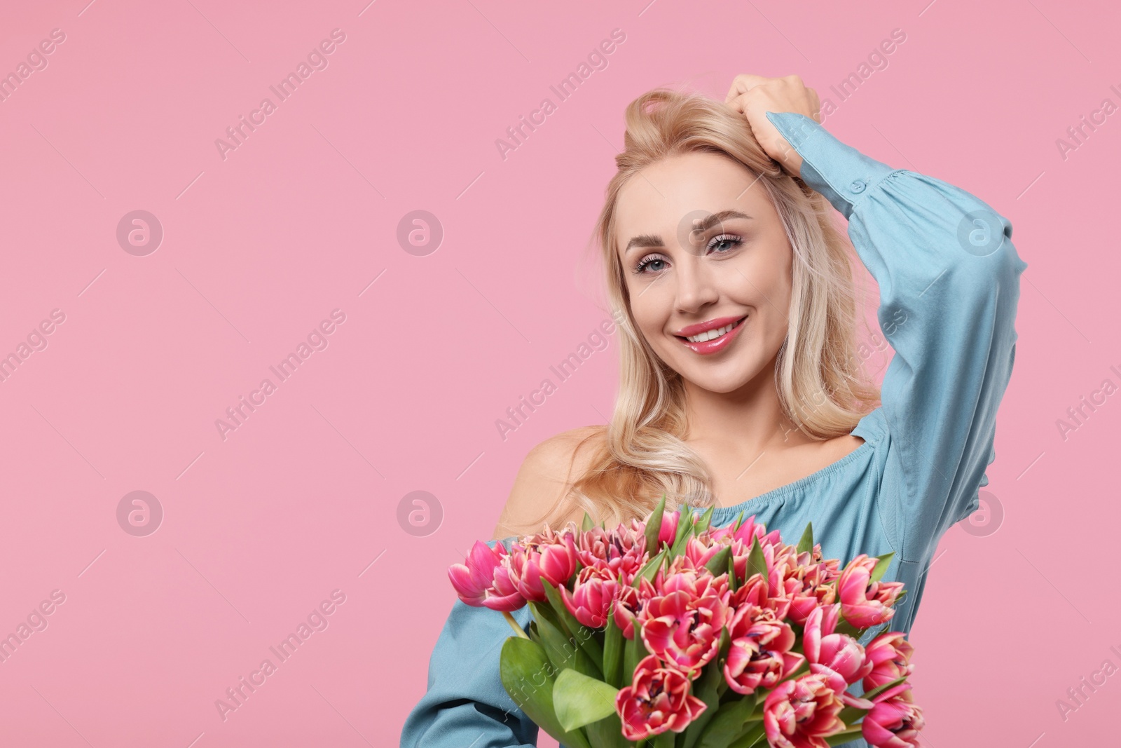 Photo of Happy young woman with beautiful bouquet on dusty pink background. Space for text