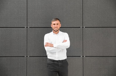 Photo of Portrait of handsome young man leaning to wall outdoors